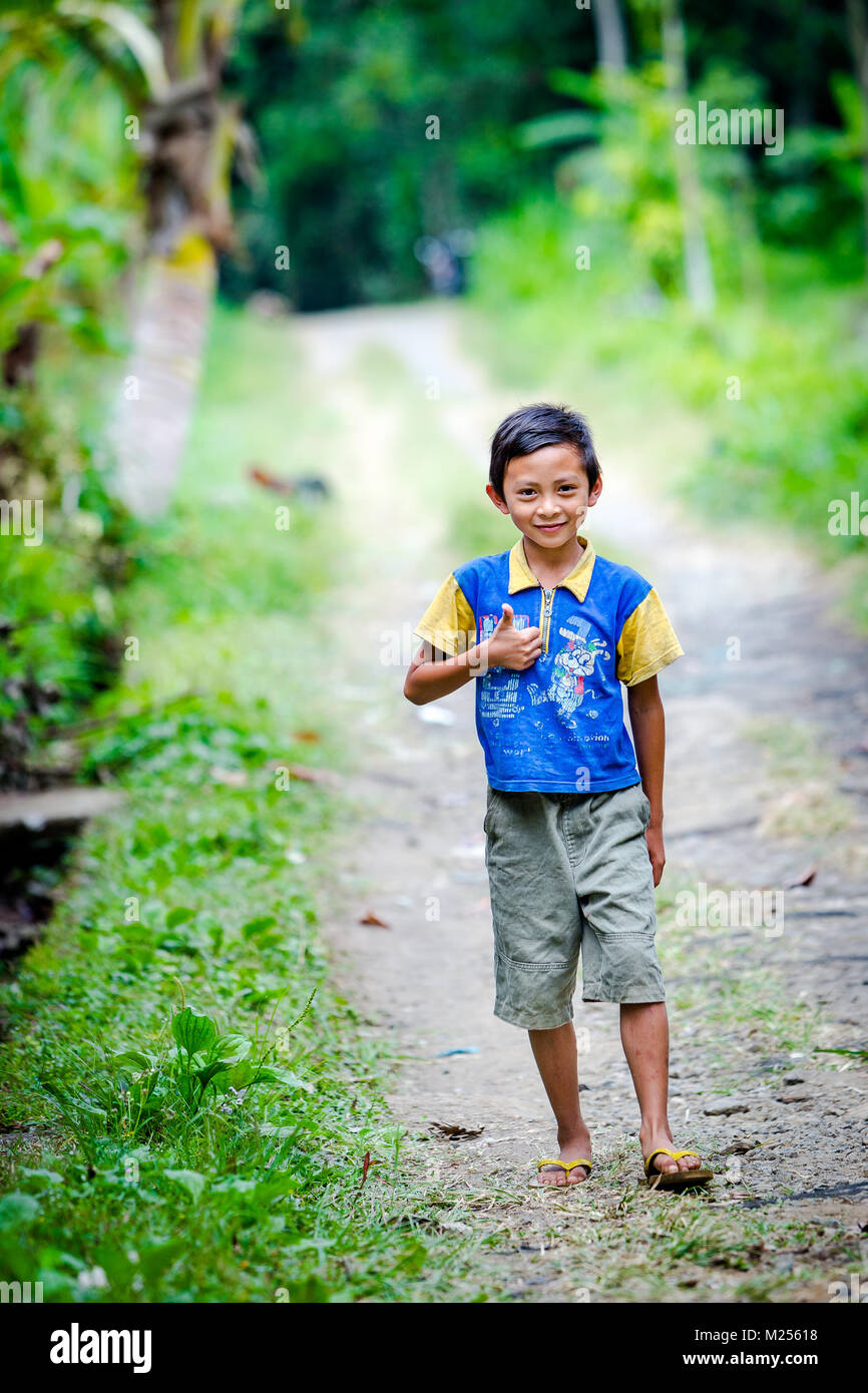Bali, Indonesia - 30 agosto 2013: Closeup ritratto di carino asiatiche ragazzo balinese all'esterno. Area di Ubud, isola di Bali, sorridente bambino Foto Stock