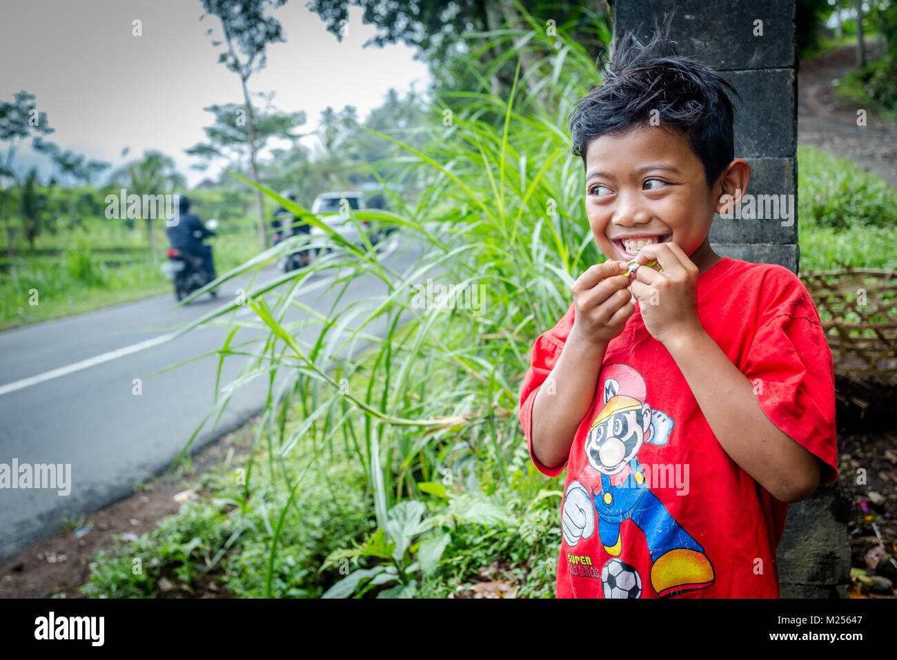 Bali, Indonesia - 30 agosto 2013: Closeup ritratto di carino asiatiche ragazzo balinese all'esterno. Area di Ubud, isola di Bali, sorridente bambino Foto Stock