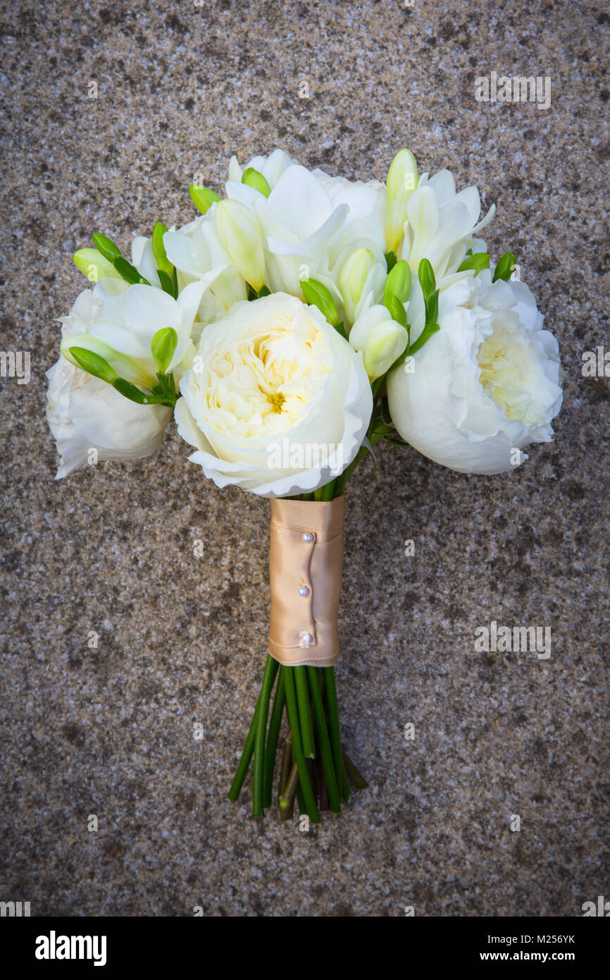 Bouquet nozze con rose bianche legato in raso, su pietra Foto Stock