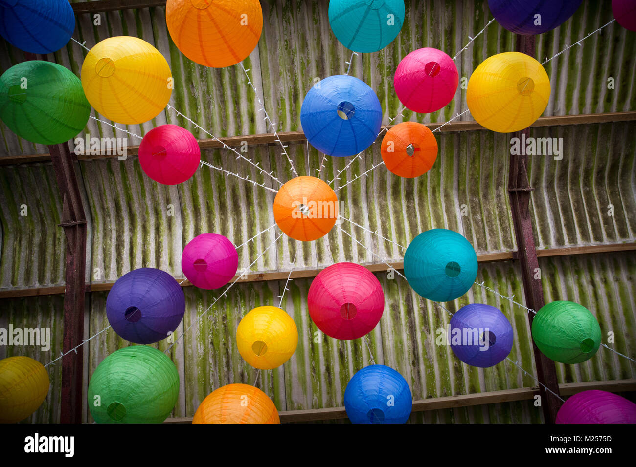 Carta colorata lanterne pendenti dal soffitto del granaio, basso angolo di visione Foto Stock
