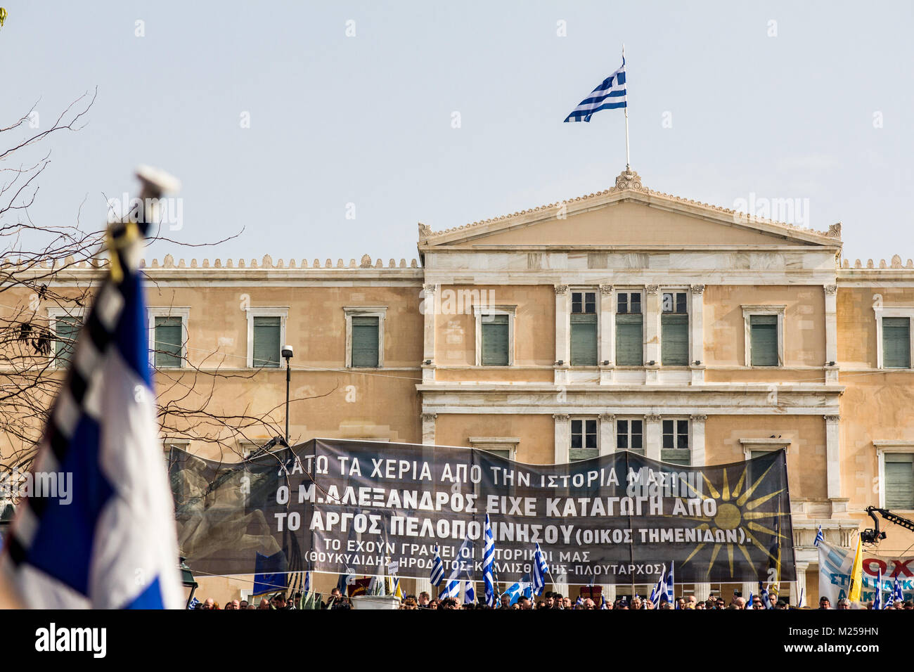 Un banner è visibile nella parte anteriore del parlamento che dice che il grande Alexander è nata greca, come l'EX REPUBBLICA IUGOSLAVA DI MACEDONIA i cittadini dichiarano di provenire da lui. I Greci raccogliere massicciamente in piazza Syntagma a dimostrare contro l' uso della denominazione 'Macedonia' dalla ex Repubblica iugoslava di Macedonia. Il nome definitivo della ex Repubblica iugoslava di stato decisivo è circa del suo ingresso nella NATO. Foto: Cronos/Kostas Pikoulas Foto Stock