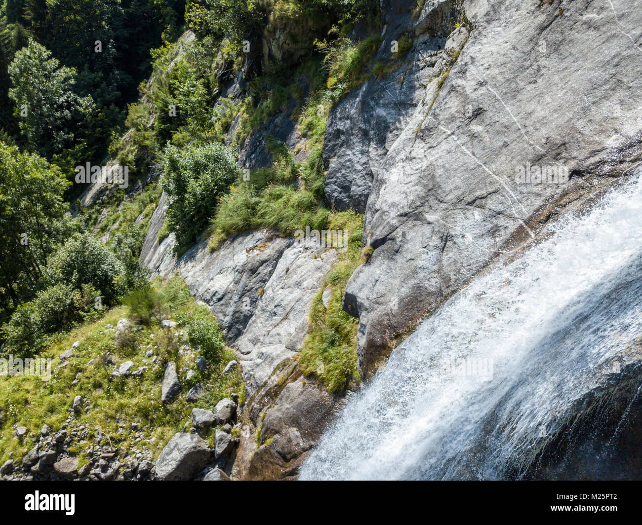 Vista aerea di una cascata in Val di Mello, una verde vallata circondata da montagne di granito e boschi, rinominato l'Italiano Yosemite Valley Foto Stock