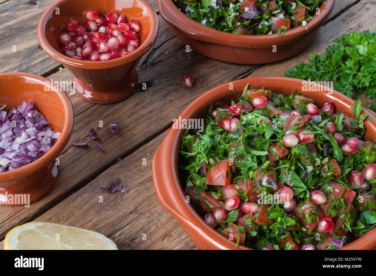Materie prime e ingredienti per insalata tabulé su tavola in legno rustico Foto Stock