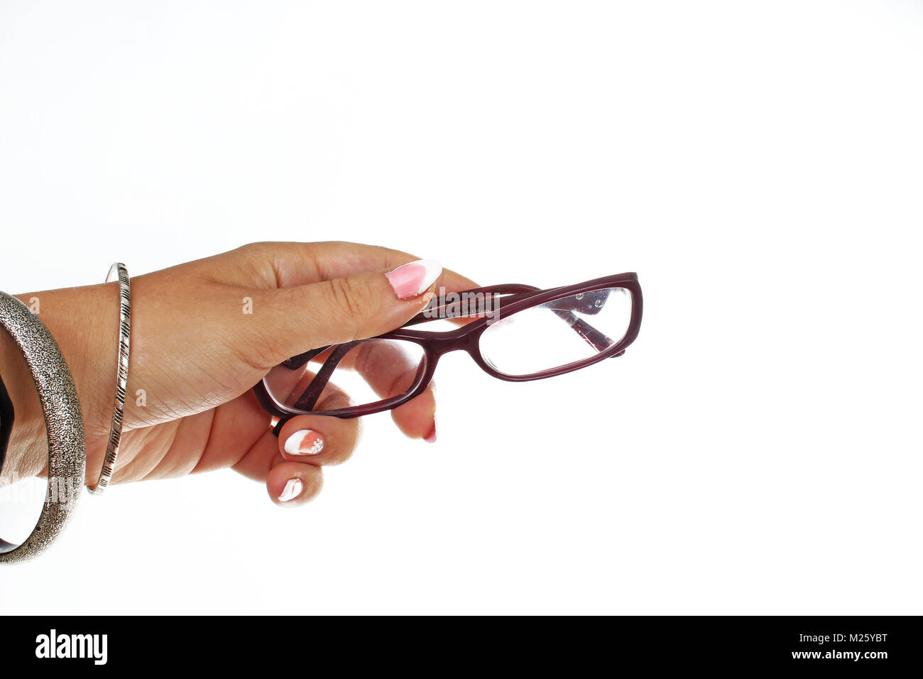 Donna mano che tiene gli occhiali da lettura OCCHIALI isolato su sfondo bianco. Studio foto con illuminazione da studio di facile utilizzo per ogni concetto. Foto Stock