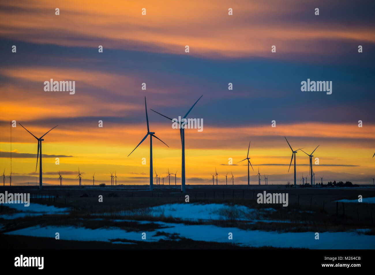 Bel tramonto con sagome di mulini a vento in primo piano; neve sulla terra; Colorado, STATI UNITI D'AMERICA Foto Stock