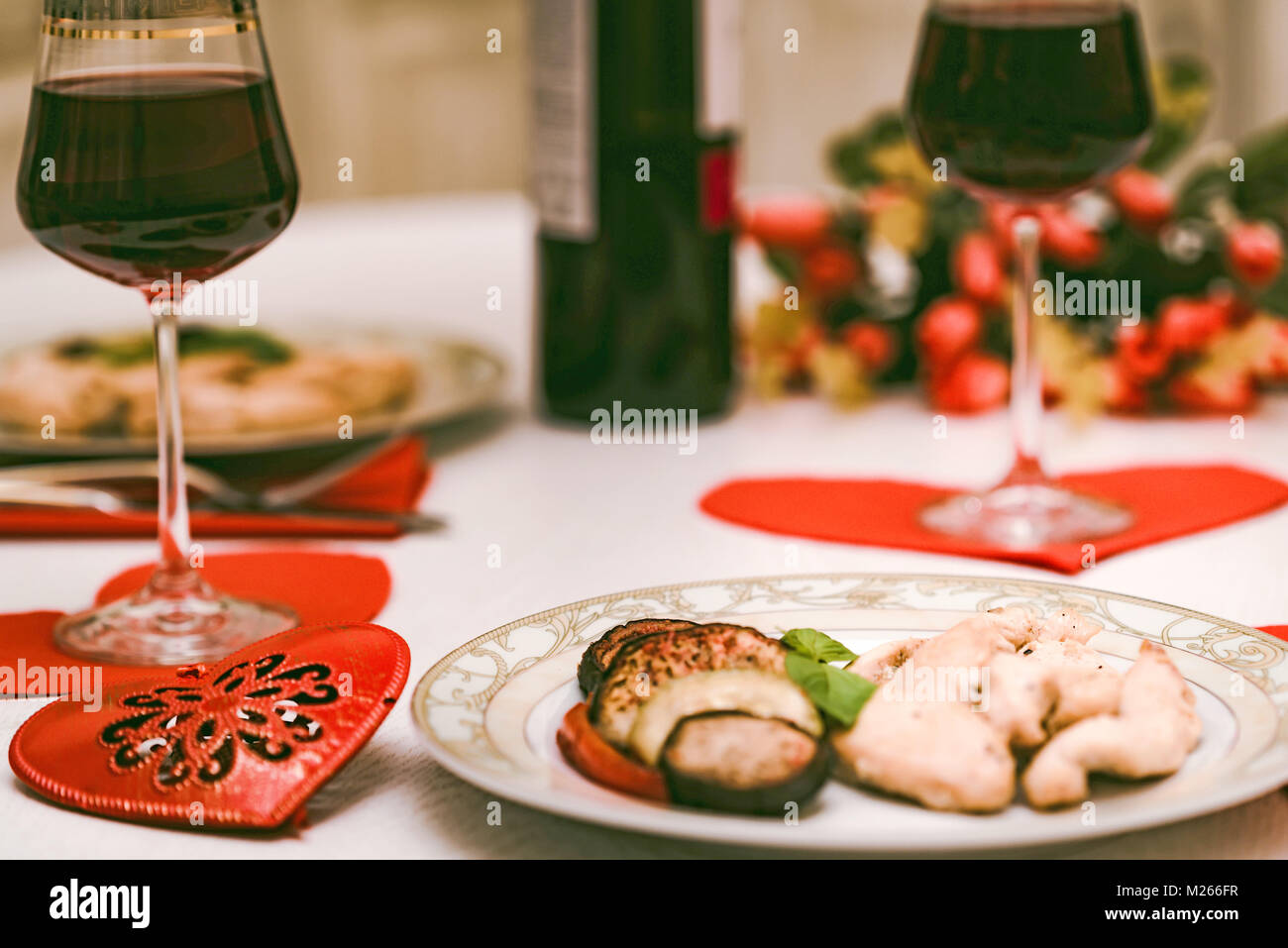 Cena romantica per due con il vino, cuore, fiori Foto Stock