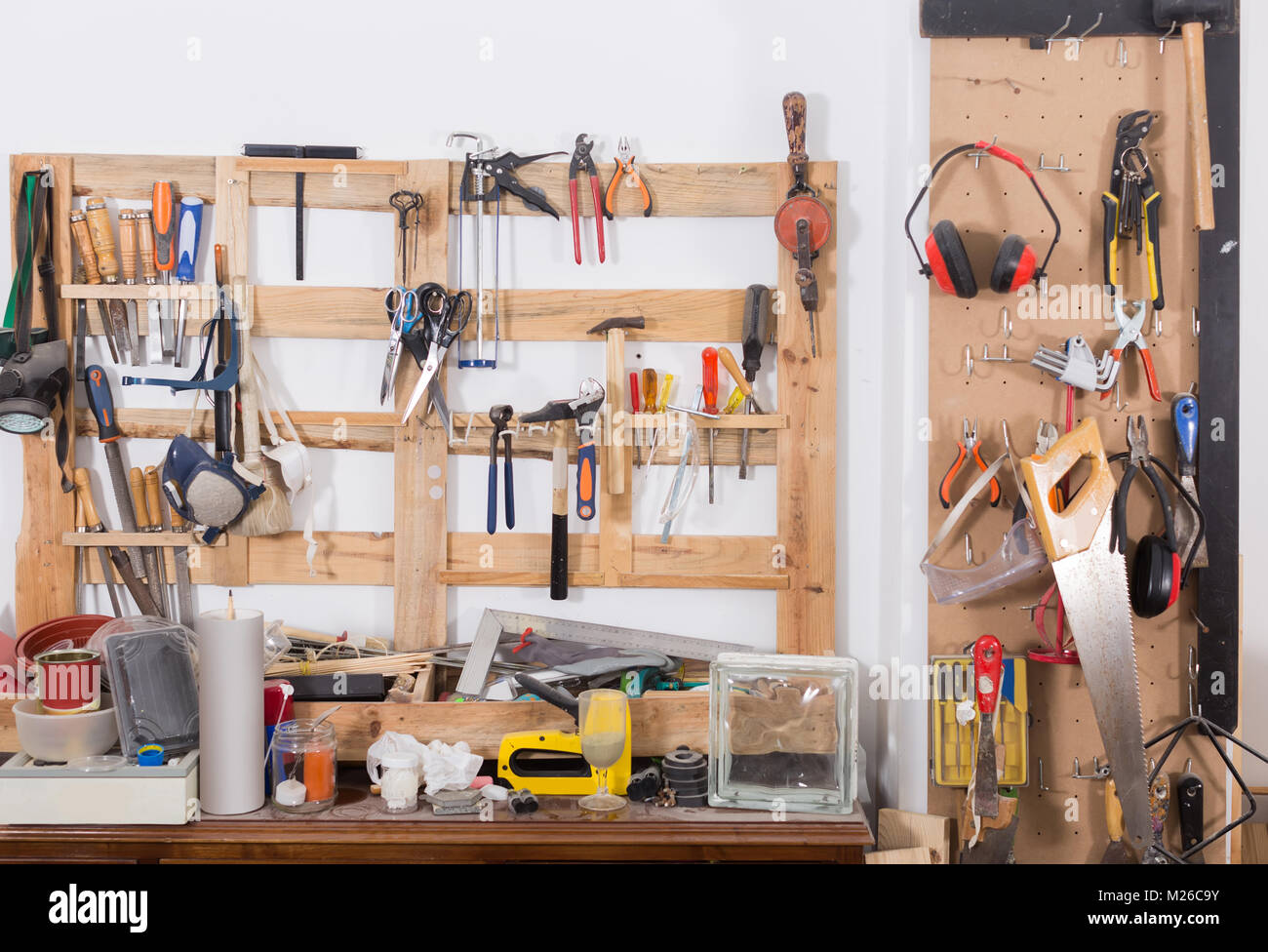 Vecchi strumenti appeso alla parete in officina, ripiano porta attrezzi  contro un muro in garage Foto stock - Alamy