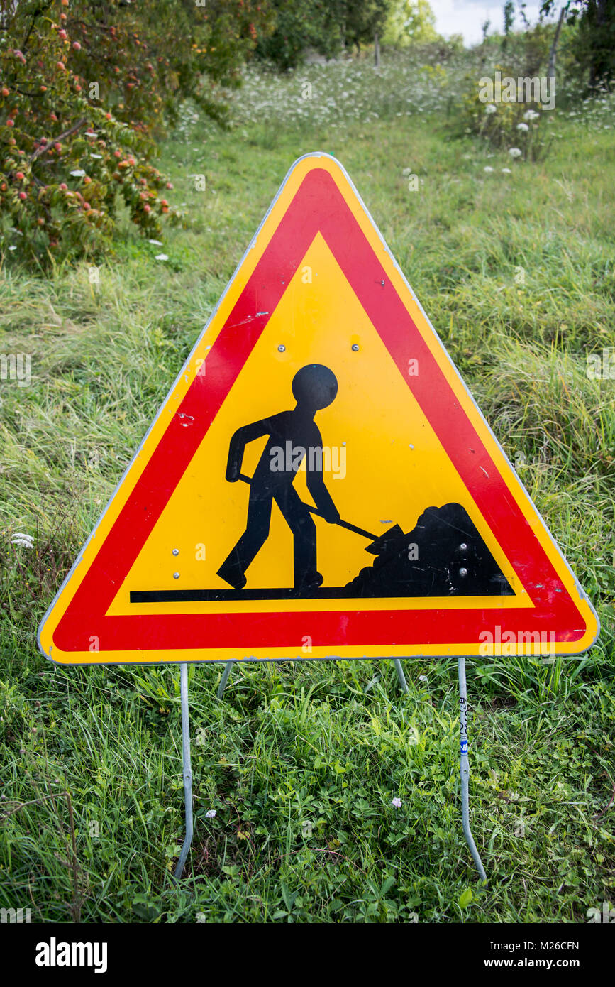 Lavorare in segno di progresso in un campo verde Foto Stock