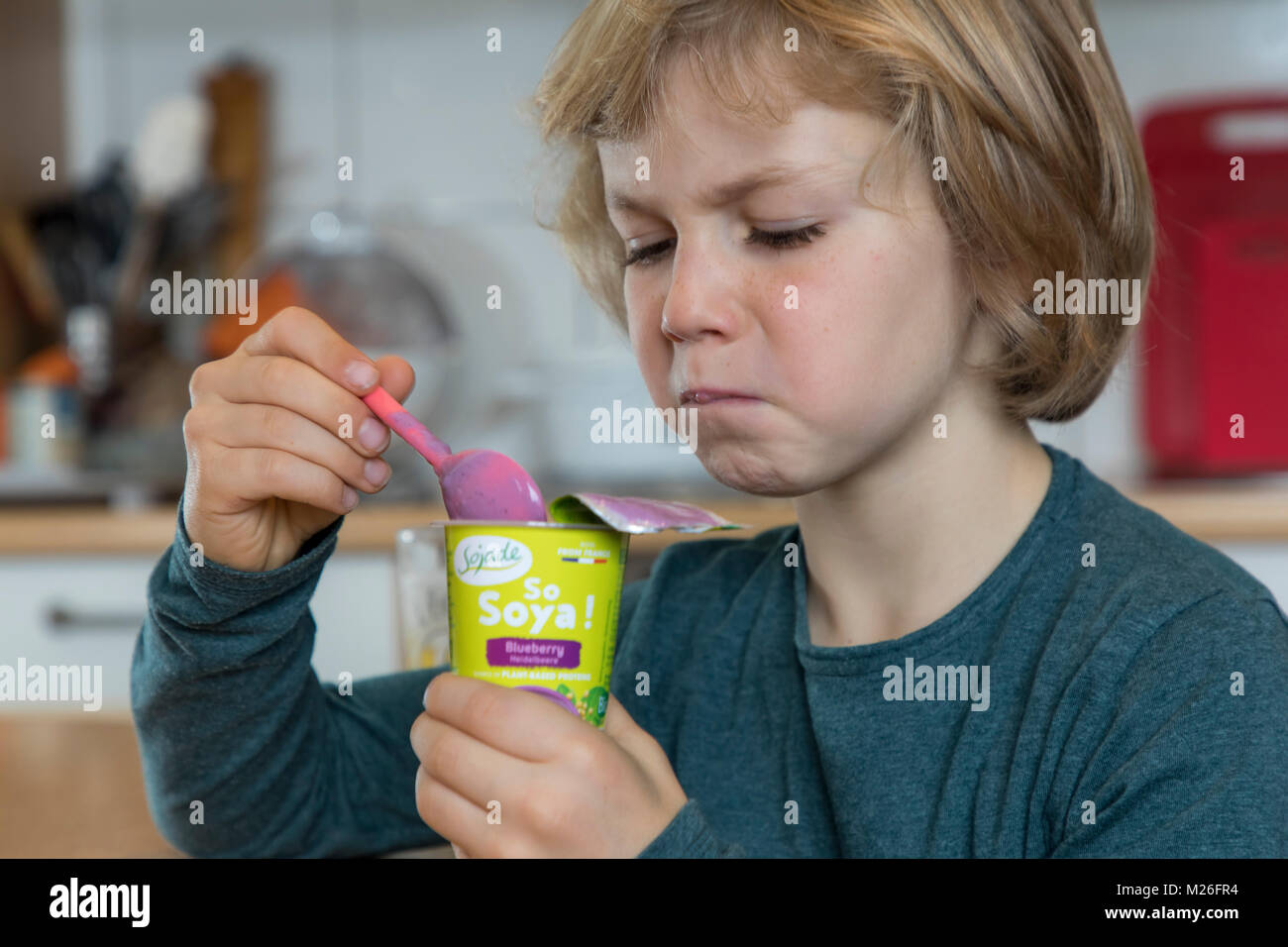 Il ragazzo, 7 anni, sapori cibo vegan, soia yogurt alla frutta sostituto, Foto Stock