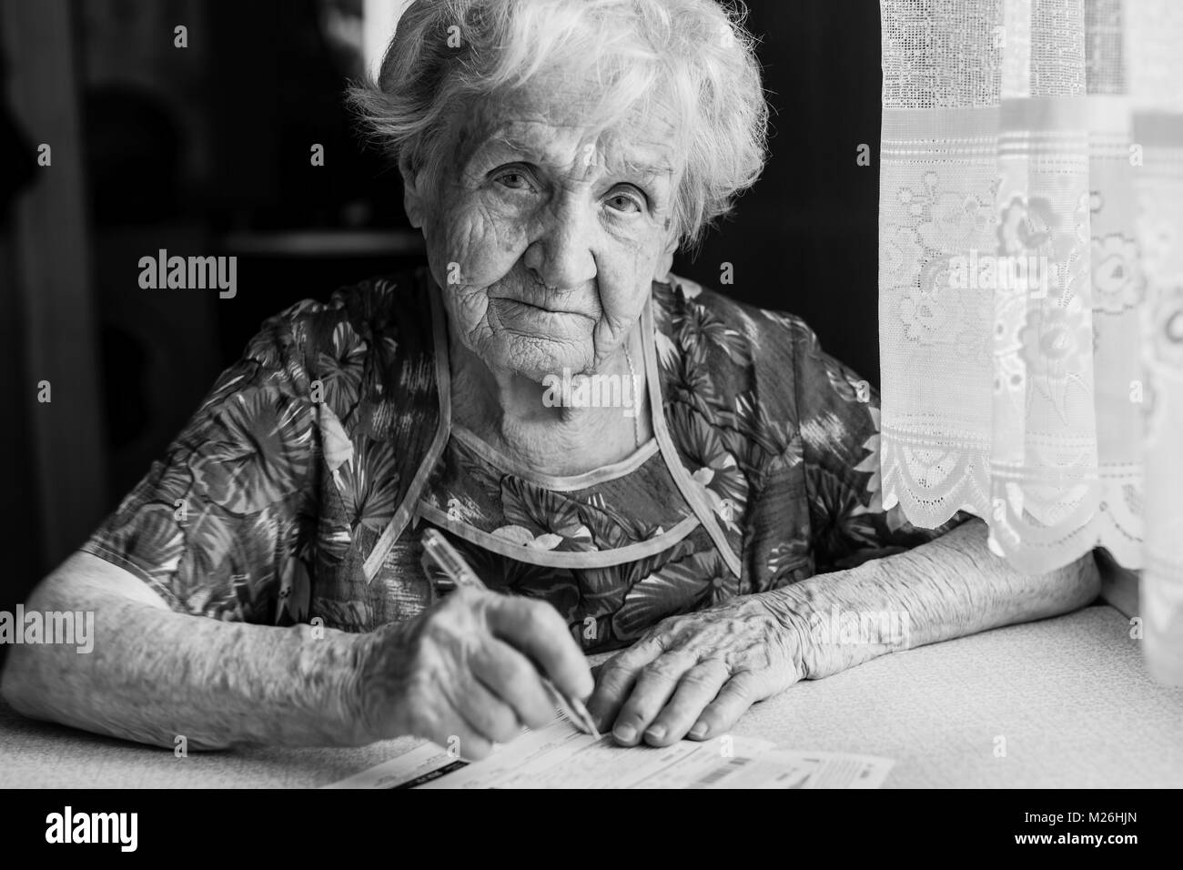 Donna anziana si riempie di entrate per servizi di pubblica utilità. Foto Stock