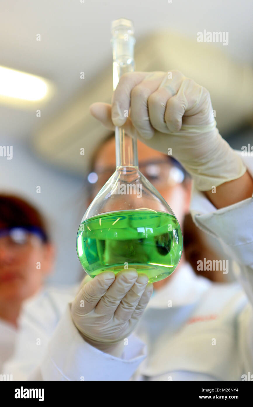 Laboratorio chimico uomo manipolare alcuni palloni Foto Stock