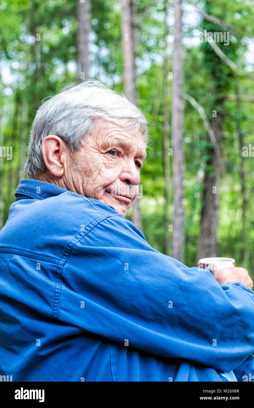 Un argento octogenarian dai capelli al di fuori della seduta Foto Stock