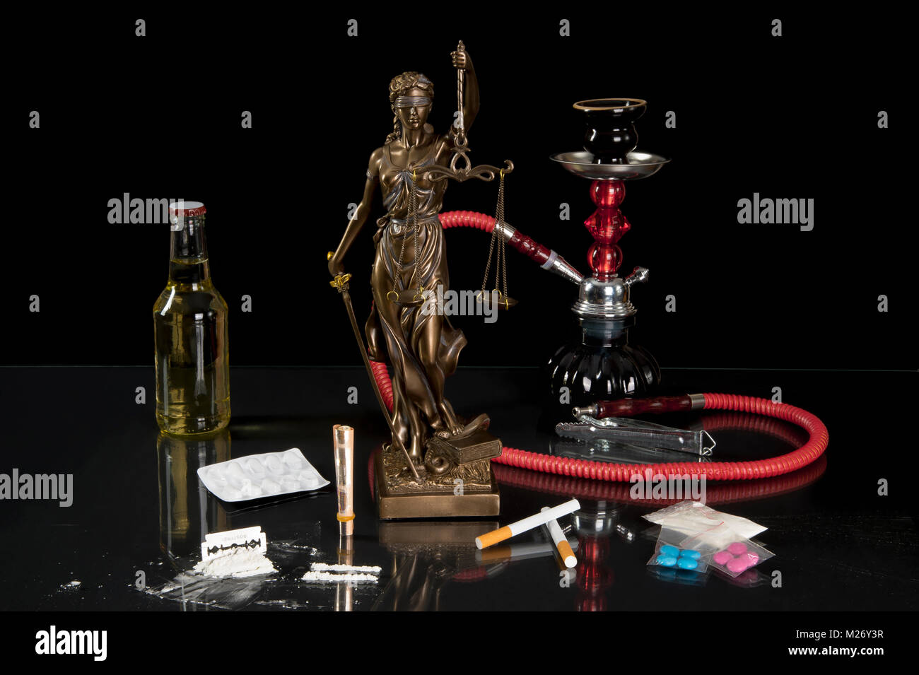 Legale e illegale intoxicants - Justitia statua in mezzo intoxicants davanti a sfondo nero Foto Stock