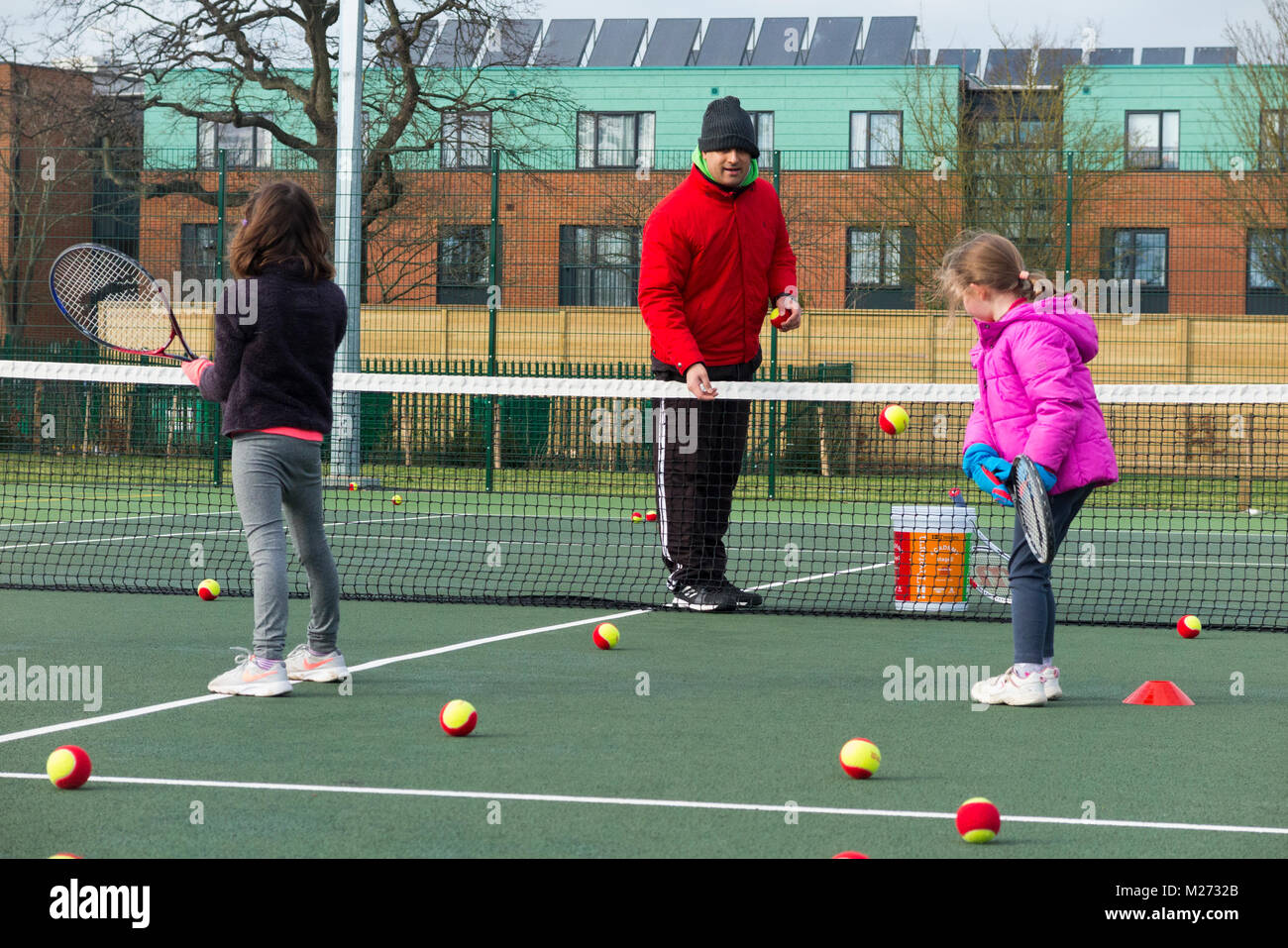 Tennis per bambini la sessione di coaching / lezione che si svolge su una  full-size campo