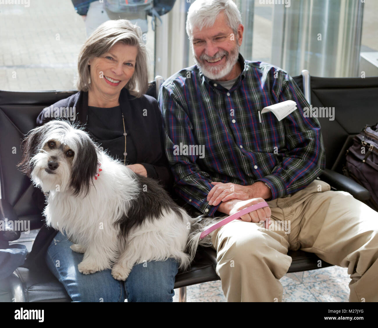 Un giovane tenere il loro cane all'Aeroporto Internazionale di Denver. Foto Stock