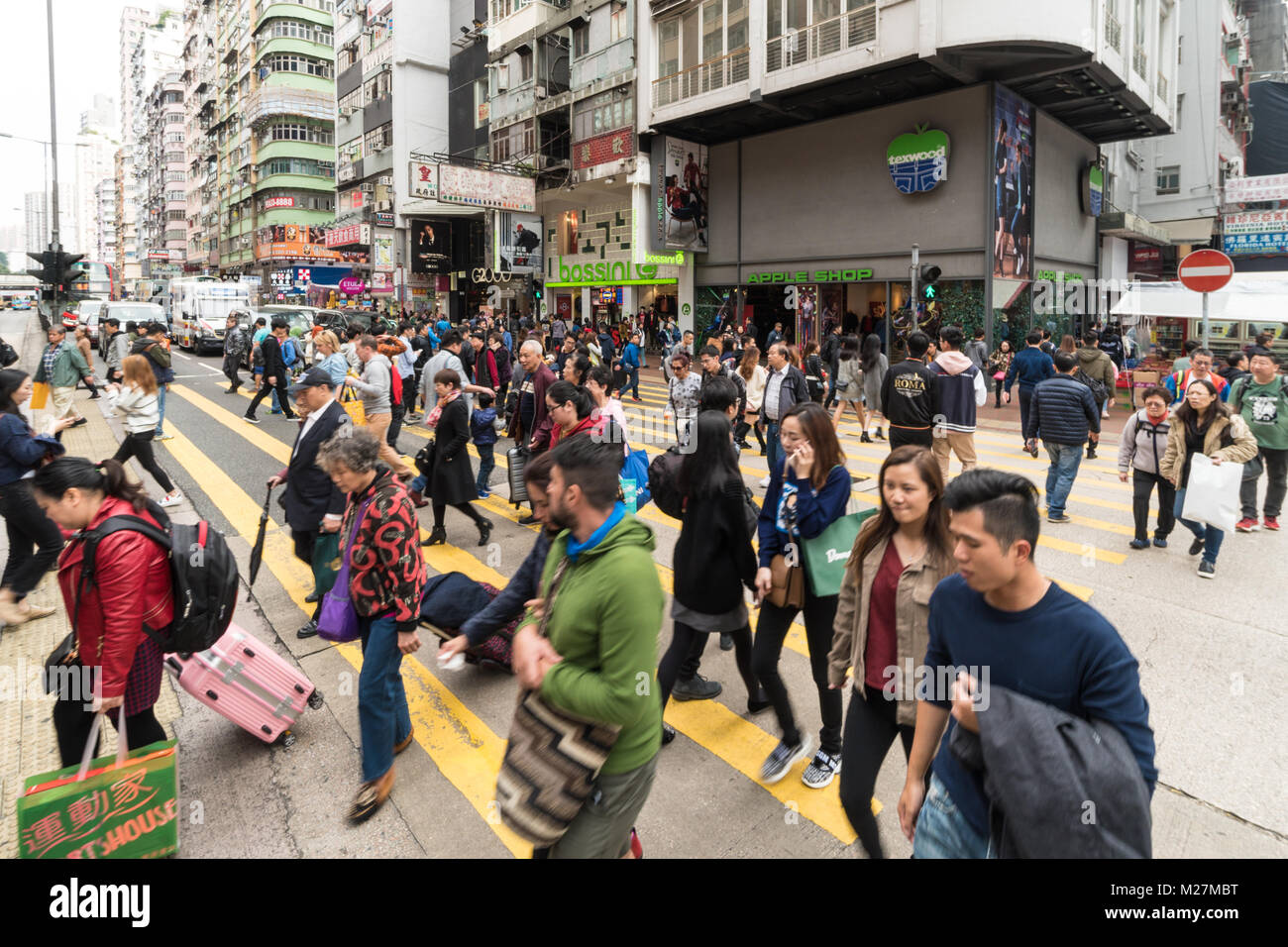 Hong Kong - 25 Gennaio 2018: persone che attraversano una strada trafficata in molto affollato Mong Kok quartiere dello shopping di Kowloon, Hong Kong Foto Stock