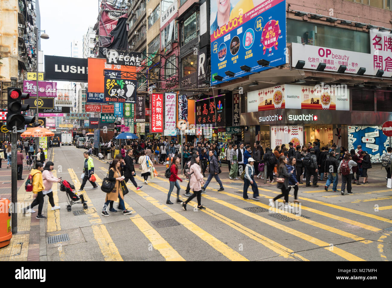 Hong Kong - 25 Gennaio 2018: persone che attraversano una strada trafficata in molto affollato Mong Kok quartiere dello shopping di Kowloon, Hong Kong Foto Stock
