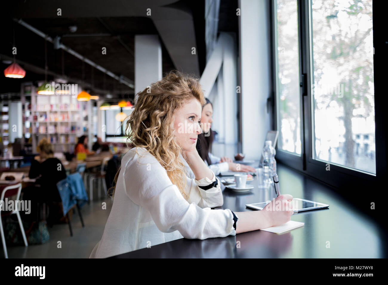 Bionda femmina caucasica concentrare in uno studio e ambiente di ufficio Foto Stock