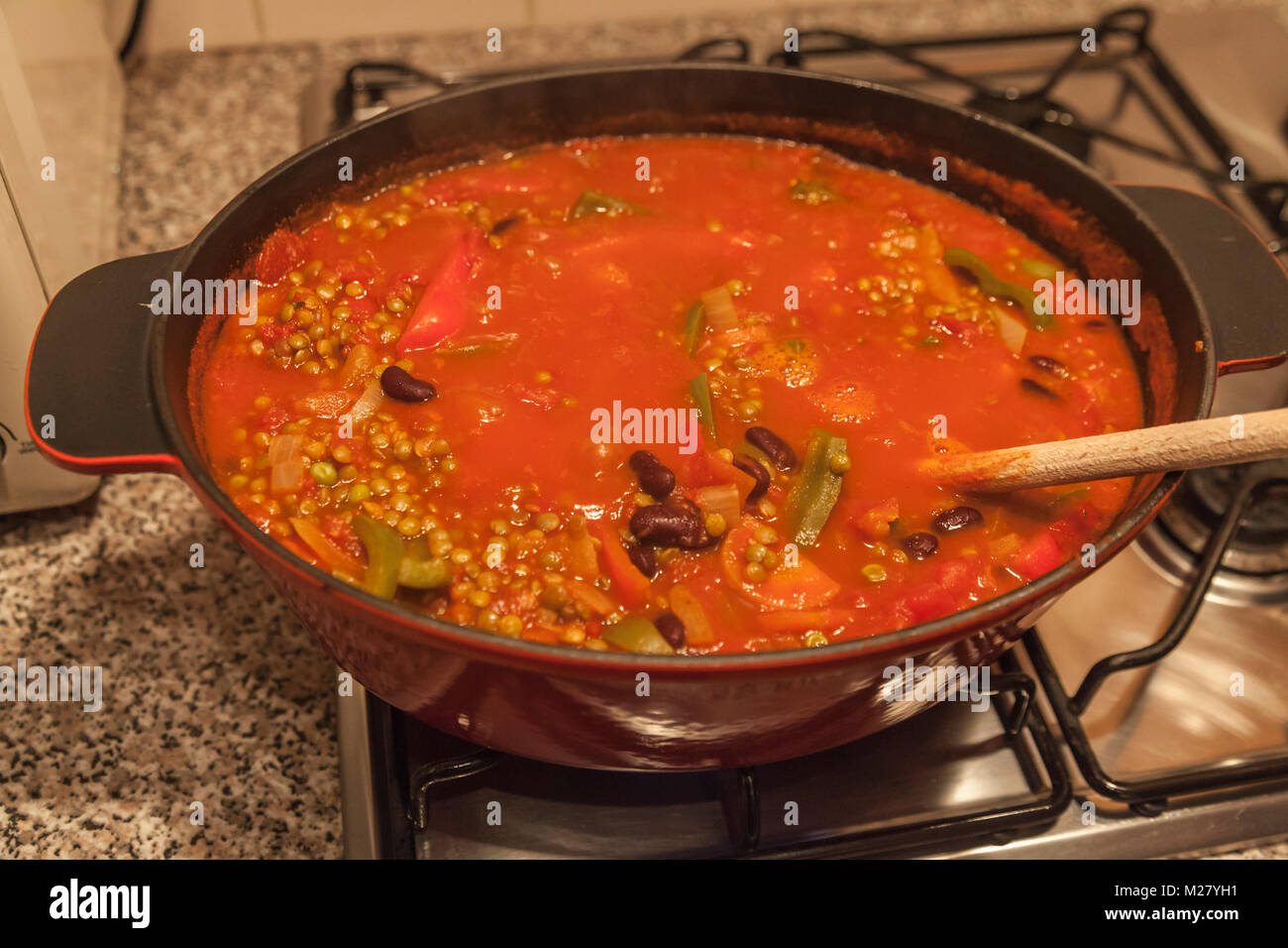 Un grande piatto di chili vegetariano su un piano cottura a gas Foto Stock