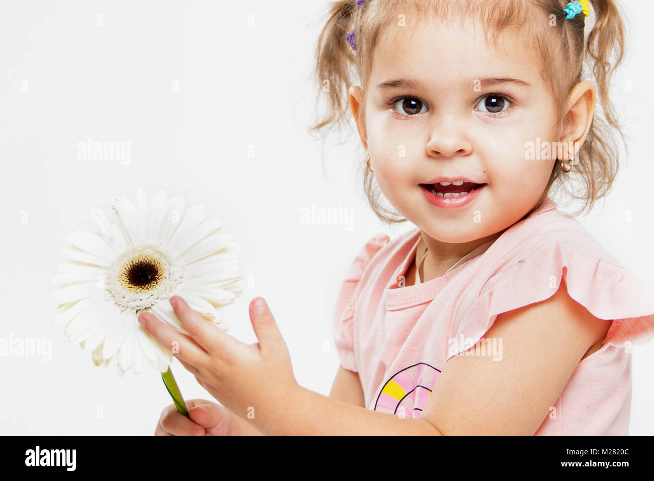 Ritratto di un bel po' di allegro girl su uno sfondo bianco. Il bambino ride Foto Stock