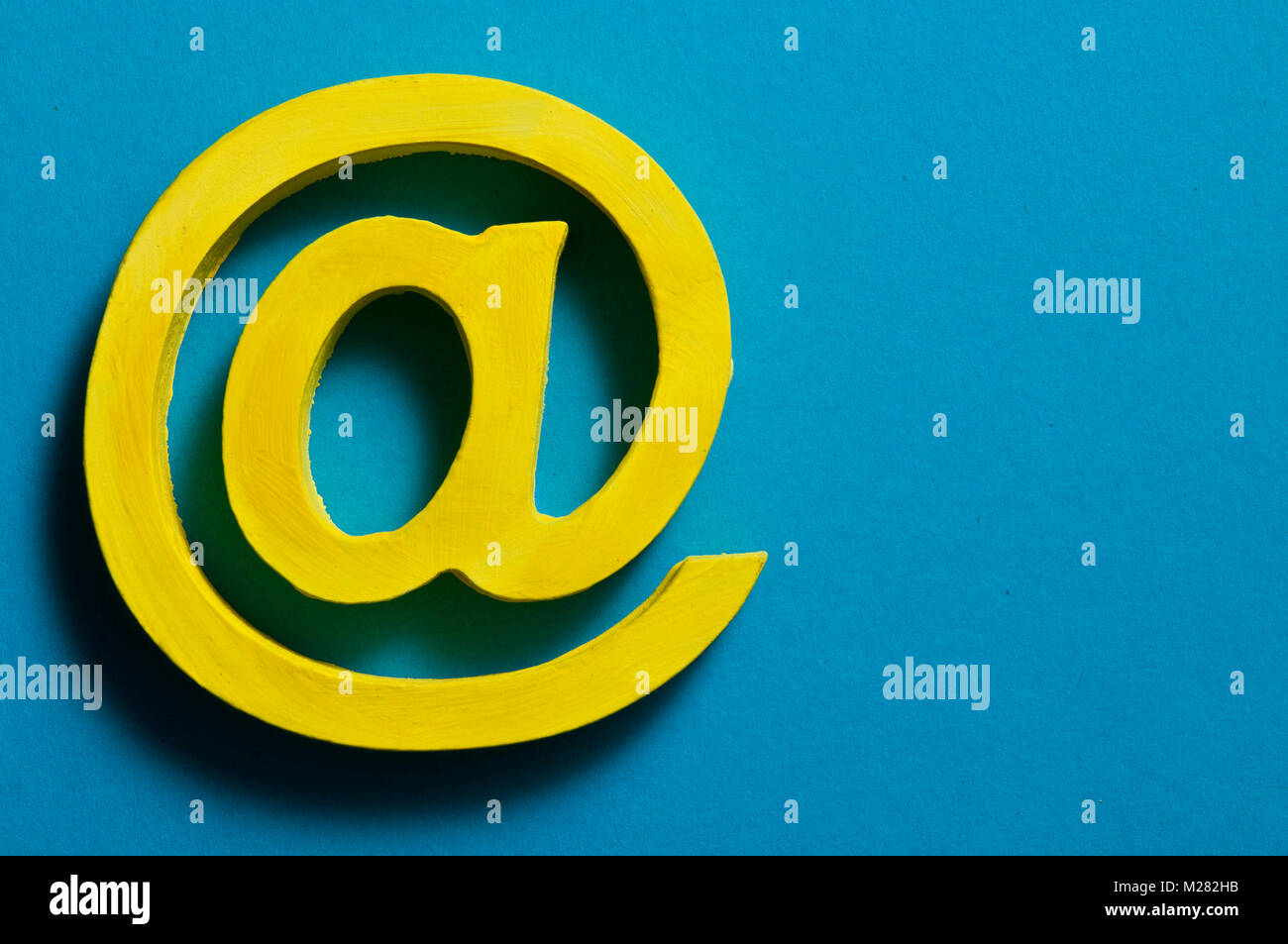 Segno @ per e-mail, giallo su blu Foto Stock
