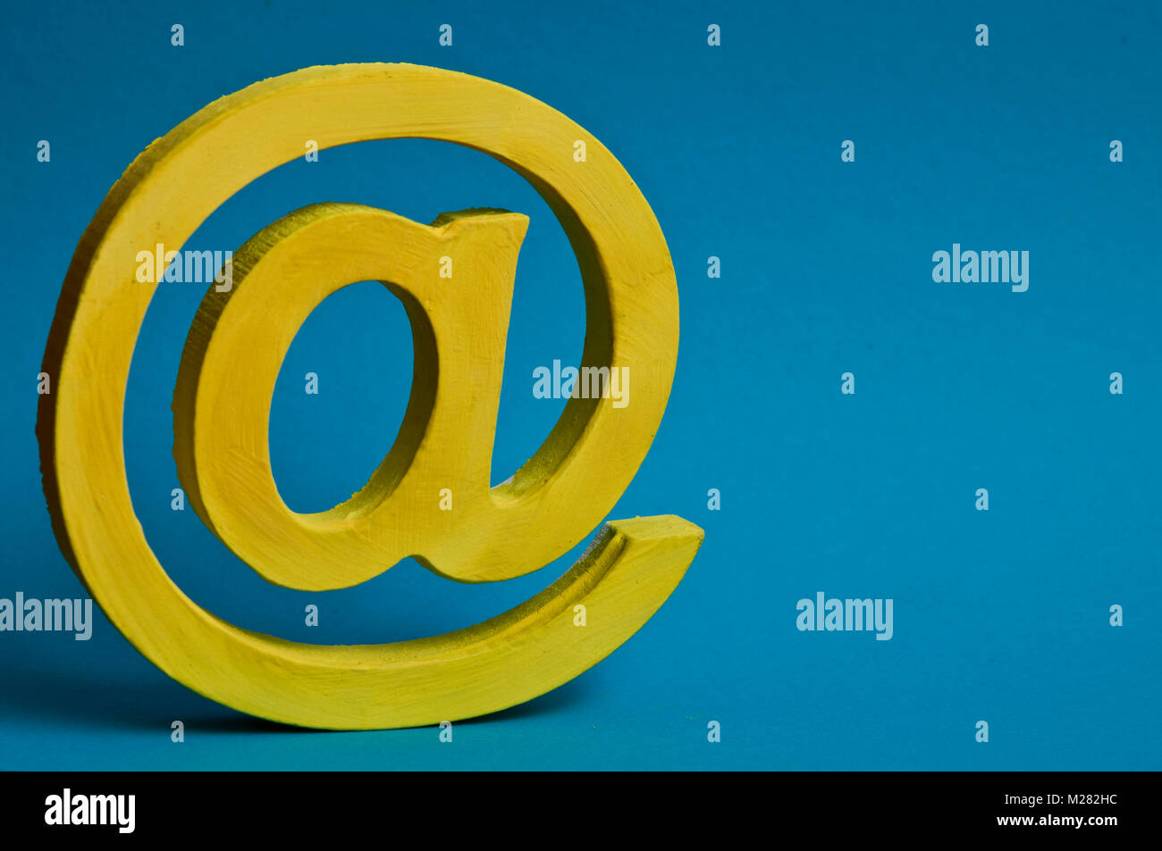 Segno @ per e-mail, giallo su blu Foto Stock
