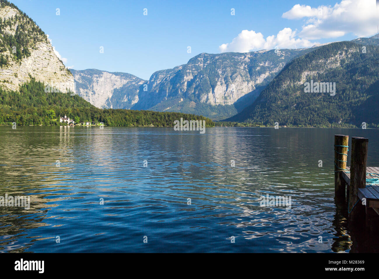 Vista del paesaggio del lago Hallstatt, noto anche come Hallstatt vedere, con acqua chiara tra alte montagne di alp sul cielo blu sullo sfondo. Foto Stock