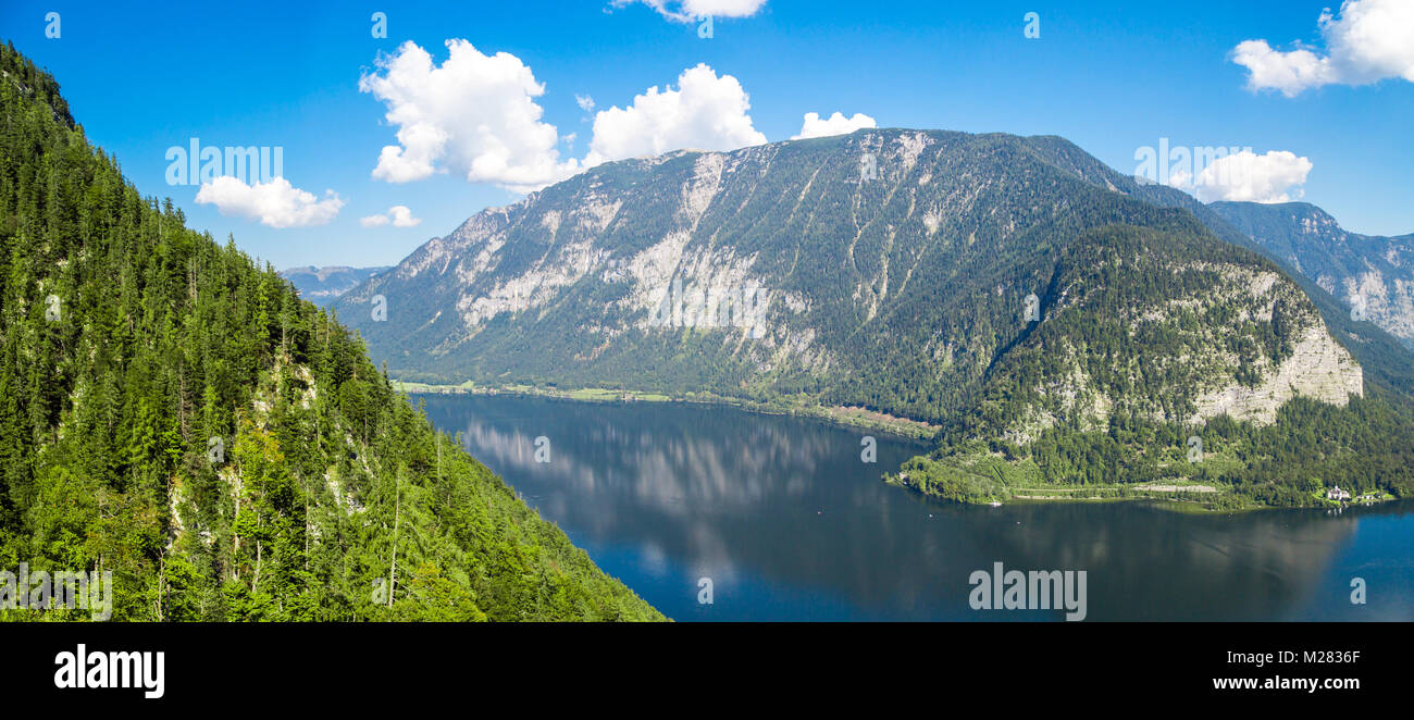 Vista del paesaggio del lago Hallstatt, noto anche come Hallstatt vedere, con acqua chiara tra alte montagne di alp sul cielo blu sullo sfondo. Foto Stock