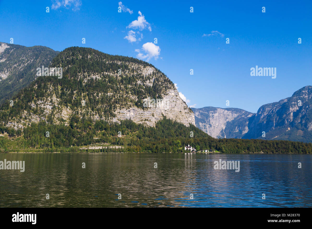 Vista del paesaggio del lago Hallstatt, noto anche come Hallstatt vedere, con acqua chiara tra alte montagne di alp sul cielo blu sullo sfondo. Foto Stock