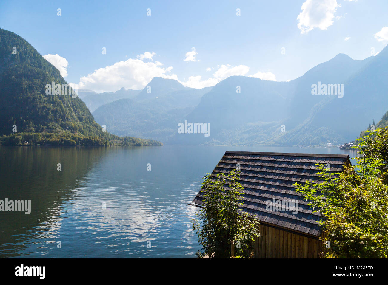 Vista del paesaggio di montagna in legno case lungo lago tra Austrian Alp montagne del Salzkammergut sul cielo blu sullo sfondo. Foto Stock