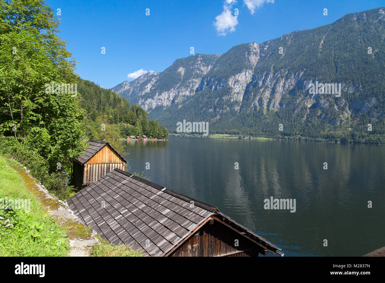 Vista del paesaggio di montagna in legno case lungo lago tra Austrian Alp montagne del Salzkammergut sul cielo blu sullo sfondo. Foto Stock