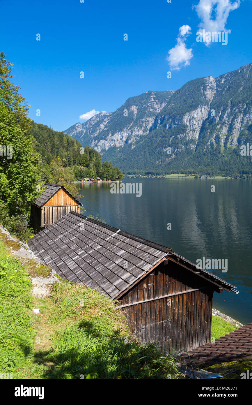 Vista del paesaggio di montagna in legno case lungo lago tra Austrian Alp montagne del Salzkammergut sul cielo blu sullo sfondo. Foto Stock
