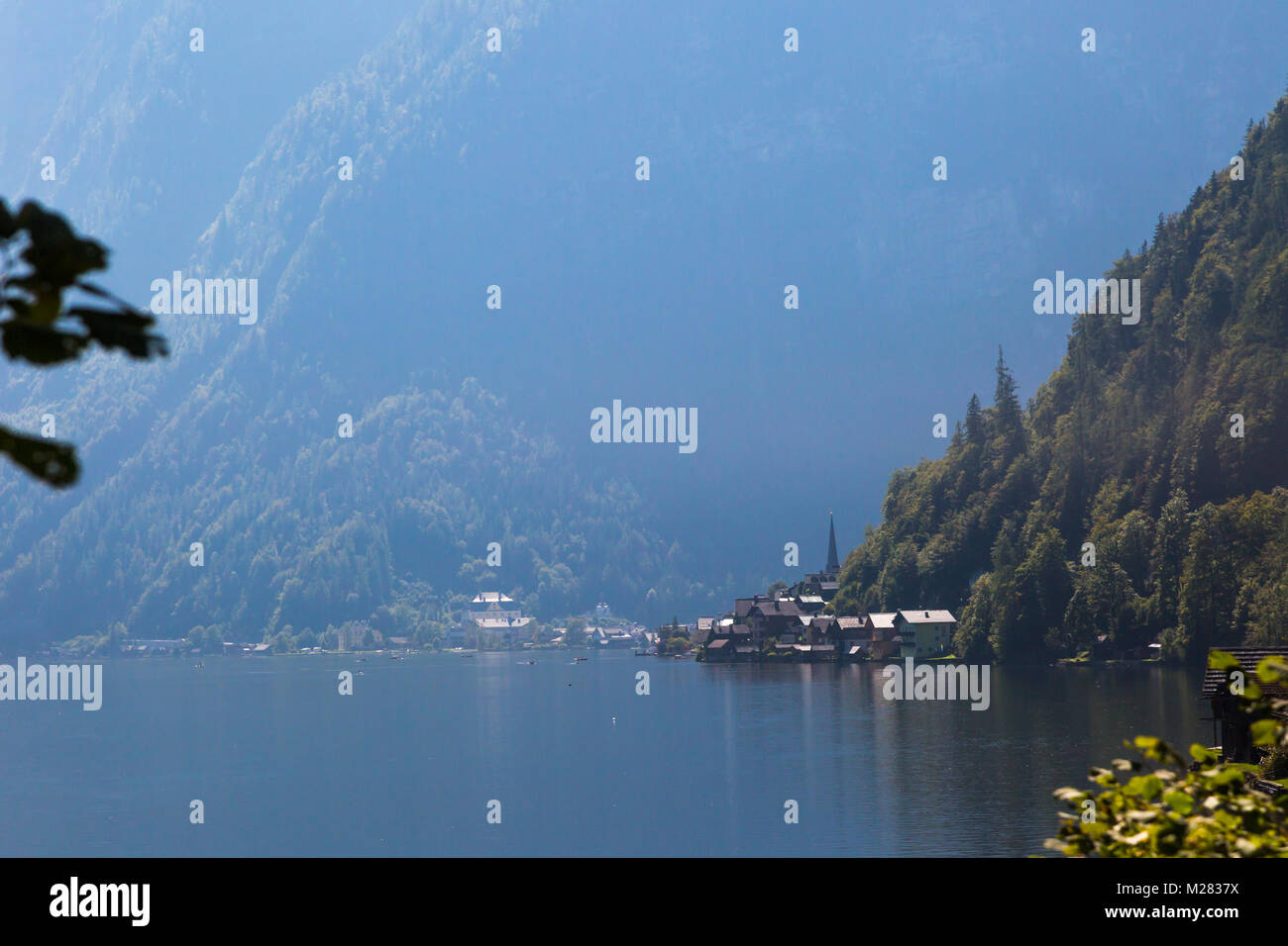 Vista del paesaggio di montagna in legno case lungo lago tra Austrian Alp montagne del Salzkammergut sul cielo blu sullo sfondo. Foto Stock