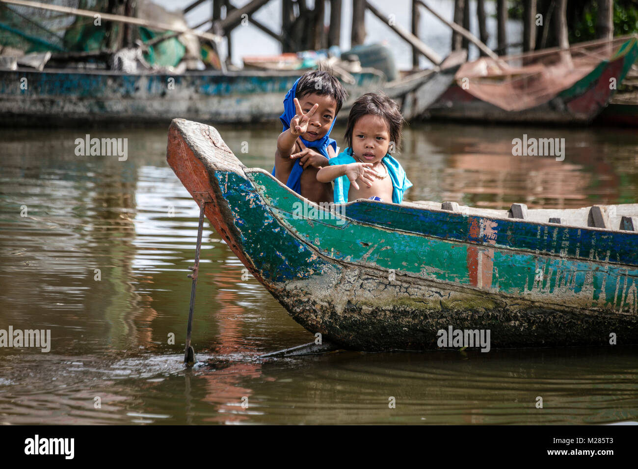 I bambini sventolano a turisti da prua della barca, Kampong Phluk villaggio galleggiante, Siem Reap Provincia, in Cambogia. Foto Stock