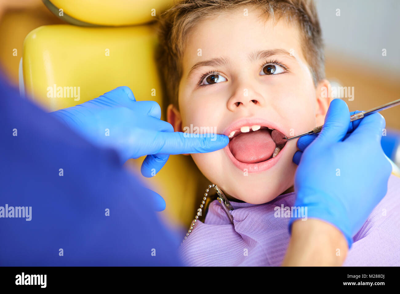 Il dentista controllo della dentatura del ragazzo adolescente. Foto Stock
