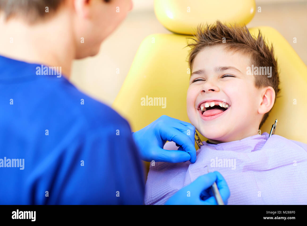 Il dentista controllo della dentatura del ragazzo adolescente. Foto Stock