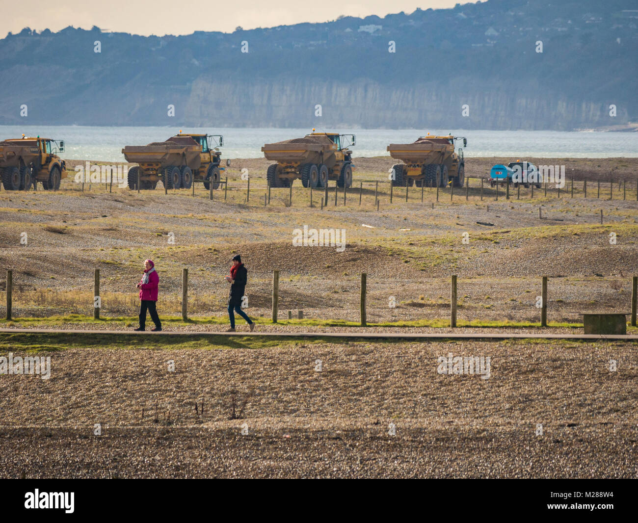 Convoglio di autocarri con cassone ribaltabile sulla costa di segale di scandole in movimento Foto Stock