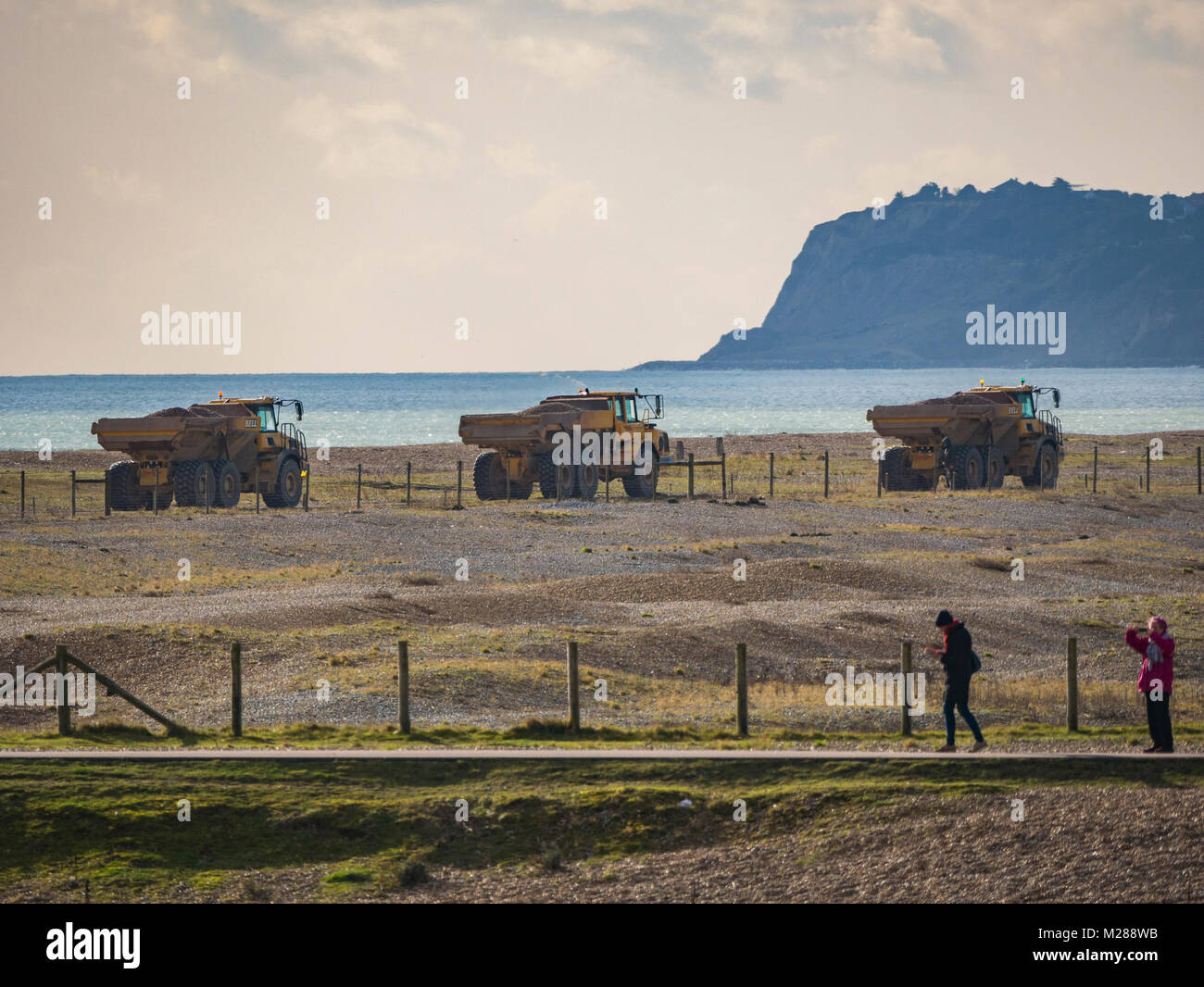 Convoglio di autocarri con cassone ribaltabile sulla costa di segale di scandole in movimento Foto Stock