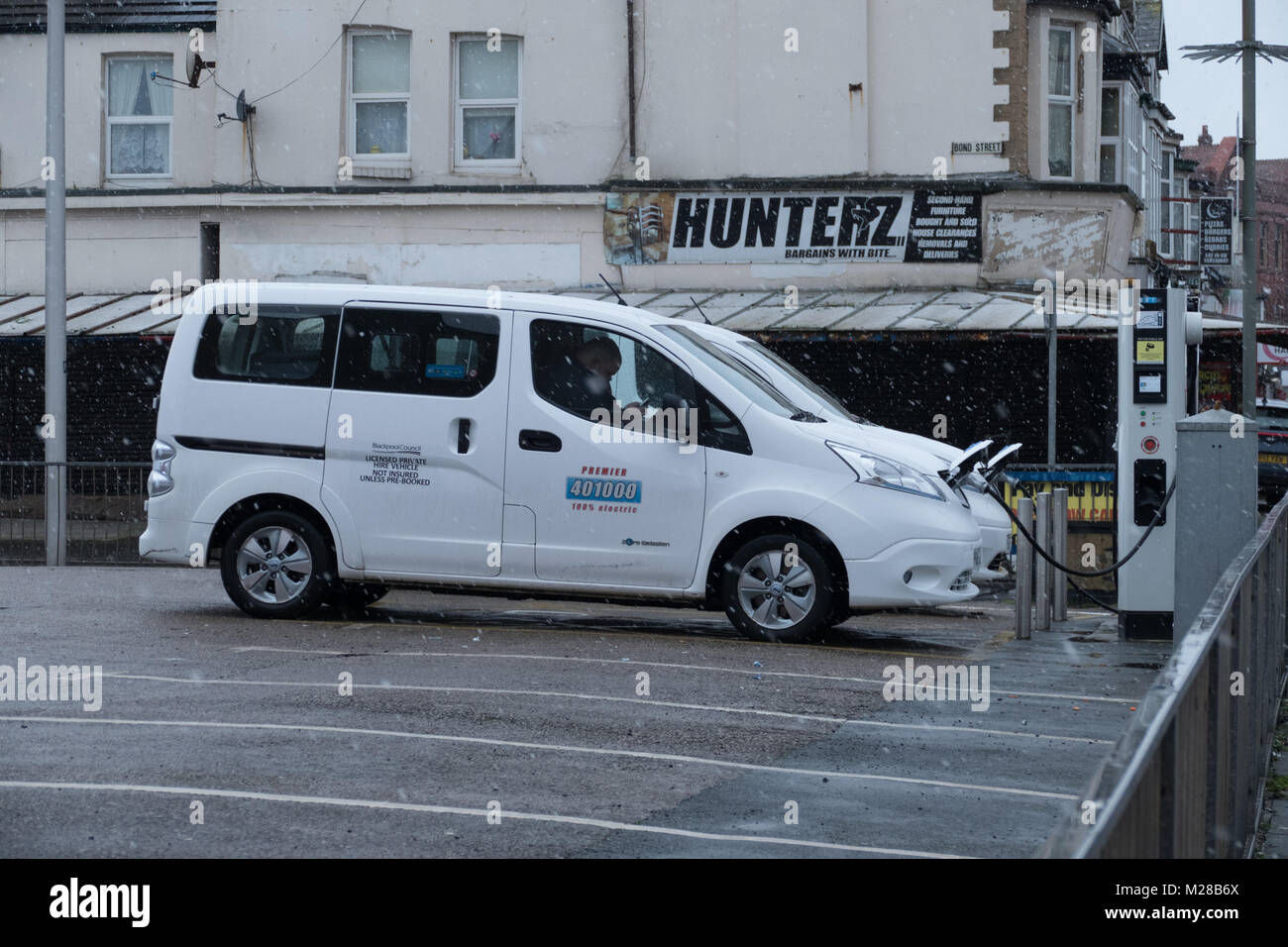 Due taxi parcheggiati in carica le batterie mentre su una pausa in Bond street car park , Blackpool. Questi nuovi Taxi sono 100% elettrico. Foto Stock