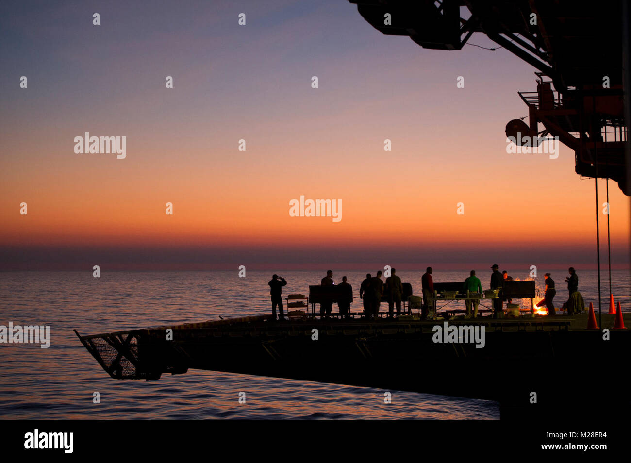 Oceano Pacifico (feb. 1, 2018) Marinai e Marines a bordo dell'assalto anfibio nave USS America (LHA 6) barbecue sulla dritta ascensore come parte di un acciaio picnic sulla spiaggia nella baia di hangar durante una crociera di Tiger. America, parte dell'America anfibio gruppo pronto, con avviato xv Marine Expeditionary Unit (MEU), è di ritorno da 7 mesi di distribuzione per gli Stati Uniti 3a, 5 e 7 settori della flotta delle operazioni. (U.S. Navy Foto Stock