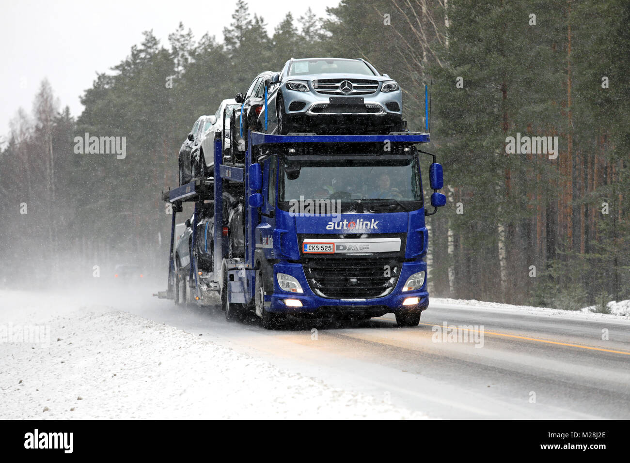 SALO, Finlandia - 3 febbraio 2018: DAF CF auto vettore di Autolink trasporta il nuovo Mercedes-Benz Cars lungo la strada in nevischio e neve. Foto Stock
