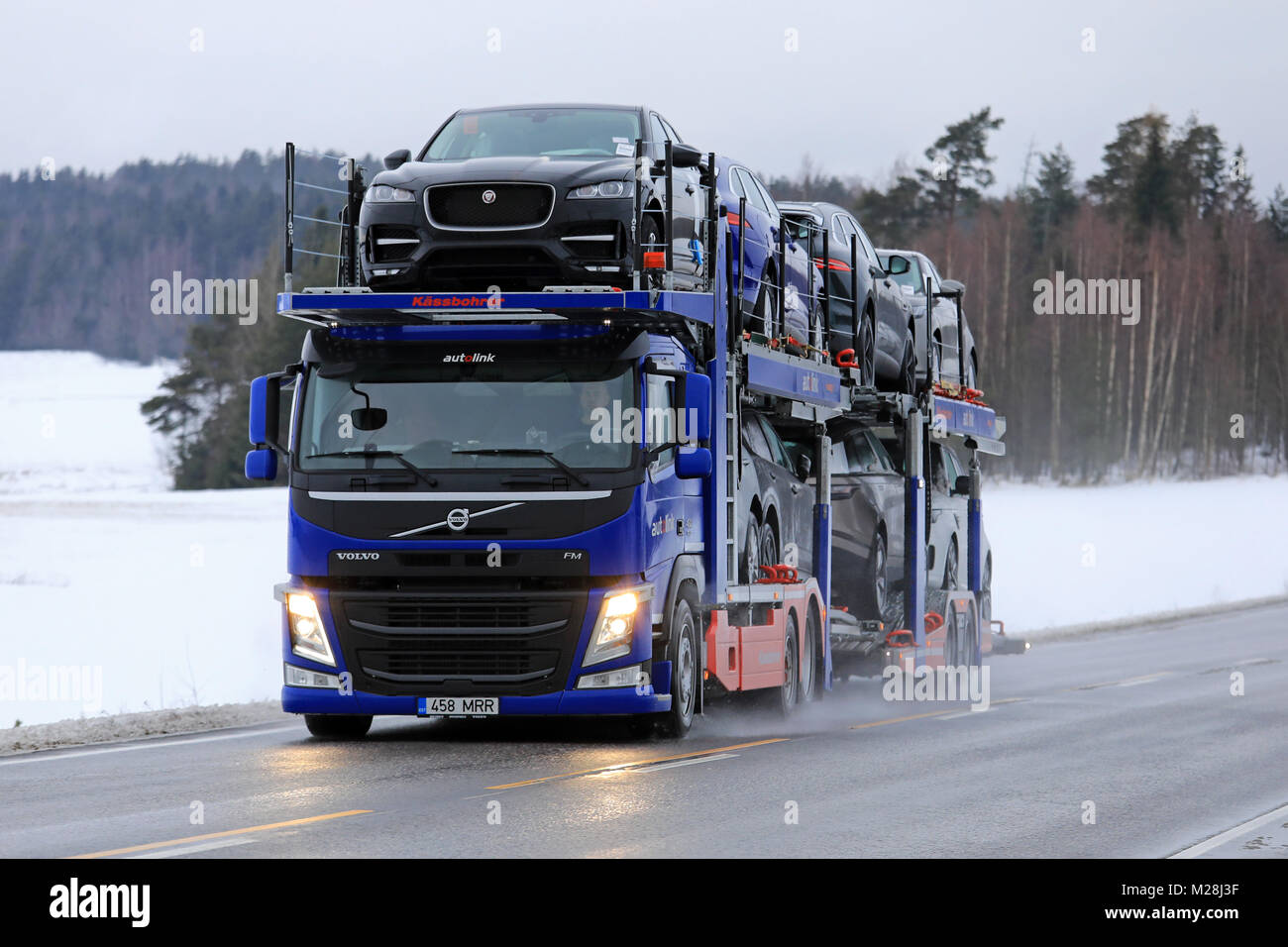 SALO, Finlandia - 2 febbraio 2018: VOLVO FM auto vettore di Autolink trasporta nuove vetture lungo la strada rurale in inverno. Foto Stock