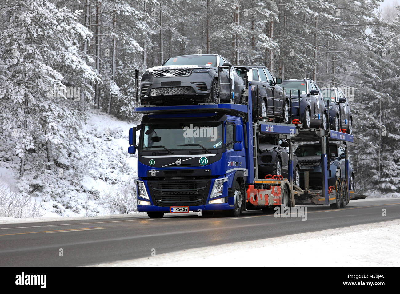 SALO, Finlandia - 20 gennaio 2018: VOLVO FM auto carrello portante della Autolink trasporta il nuovo Range Rover auto lungo la strada rurale in inverno. Foto Stock