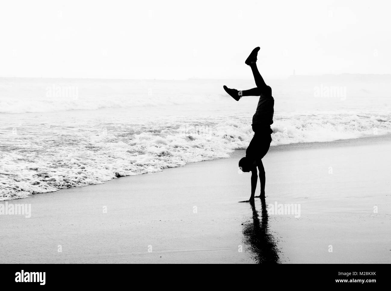 Headstand su una spiaggia in Ghana Foto Stock