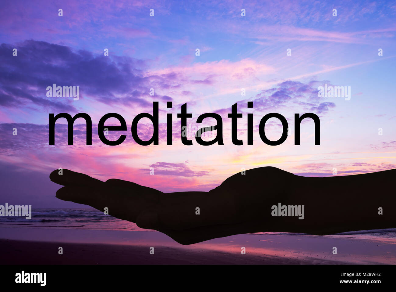 Offerta di mano la parola meditazione, sfondo al tramonto Foto Stock
