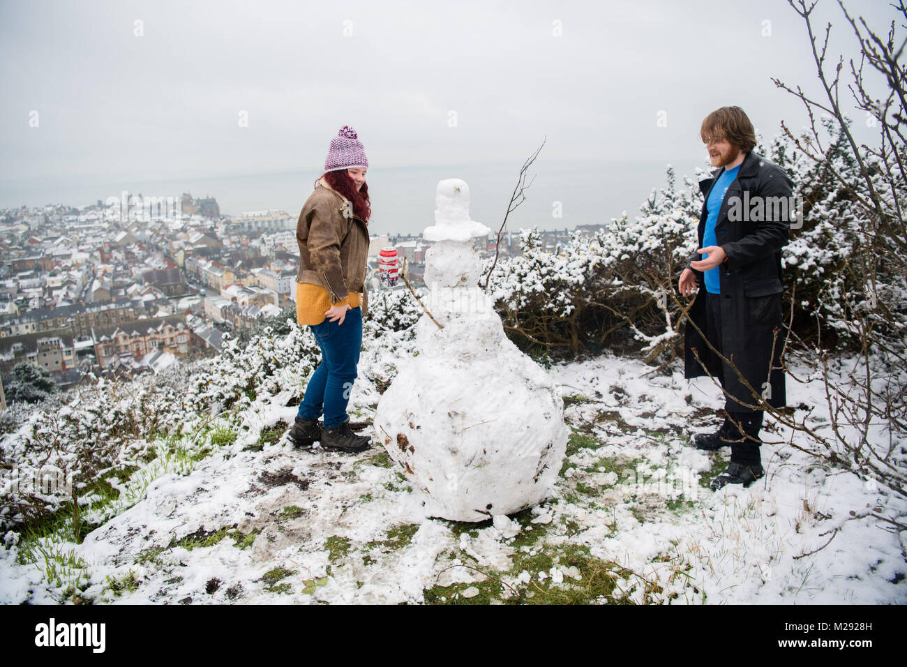 Aberystwyth, Ceredigion nel Galles, martedì 06 FebJanuary 2018 UK Meteo: studenti da Aberystwyth University prendere tempo fuori dal loro gli studi universitari per fare un pupazzo di neve sulla collina che si affaccia sulla città di mare , dopo una mattinata di neve pesante ha coperto la zona , trasformandolo in un paesaggio bianco, in una fredda mattina di febbraio il Met Office ha rilasciato un 'giallo' avvertenza per la neve e il ghiaccio, come una banda di nevischio e neve si sposta da ovest, a coprire gran parte del Galles e il nord dell'Inghilterra Photo credit: Keith Morris / Alamy Live News Foto Stock