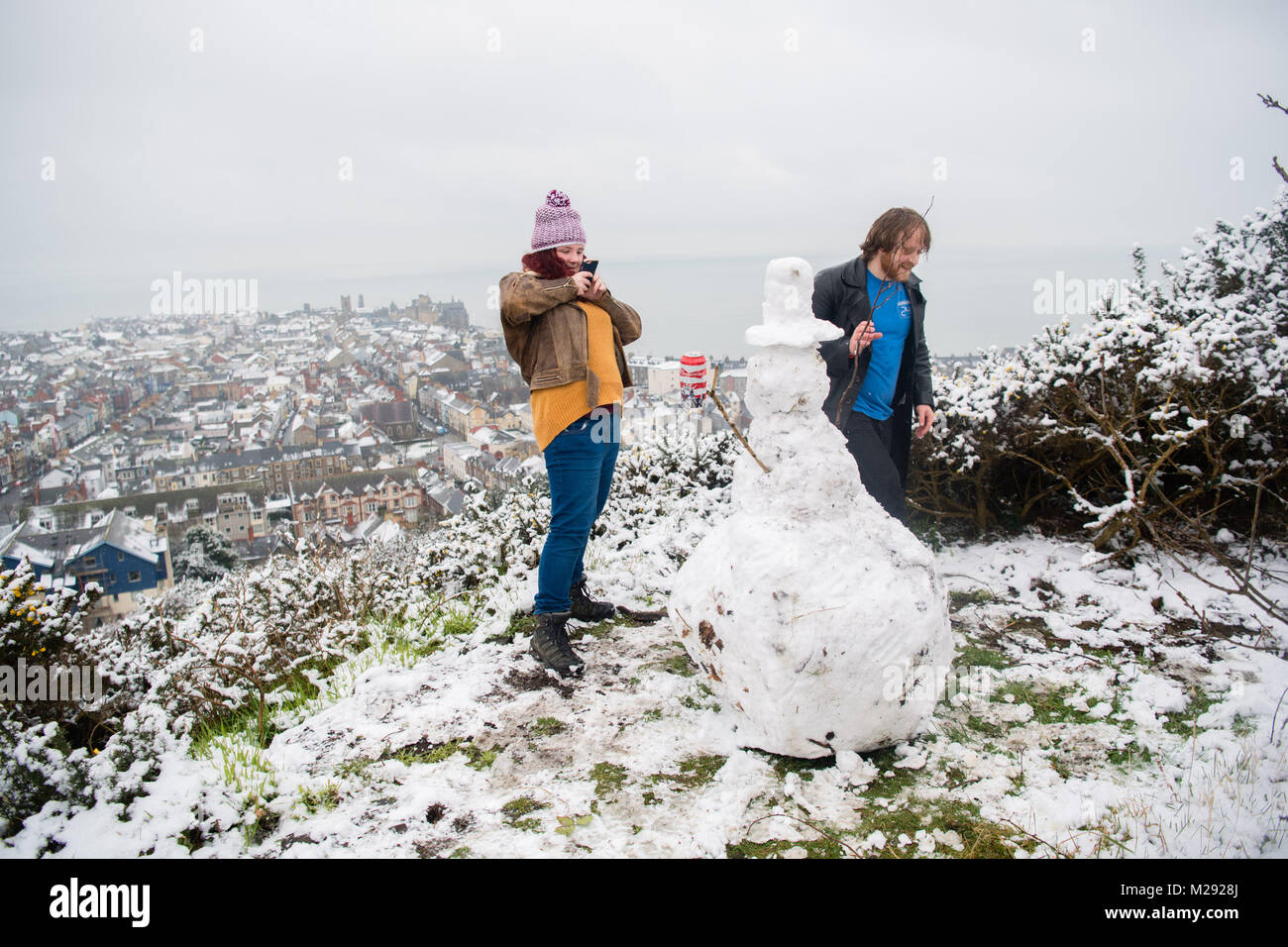 Aberystwyth, Ceredigion nel Galles, martedì 06 FebJanuary 2018 UK Meteo: studenti da Aberystwyth University prendere tempo fuori dal loro gli studi universitari per fare un pupazzo di neve sulla collina che si affaccia sulla città di mare , dopo una mattinata di neve pesante ha coperto la zona , trasformandolo in un paesaggio bianco, in una fredda mattina di febbraio il Met Office ha rilasciato un 'giallo' avvertenza per la neve e il ghiaccio, come una banda di nevischio e neve si sposta da ovest, a coprire gran parte del Galles e il nord dell'Inghilterra Photo credit: Keith Morris / Alamy Live News Foto Stock