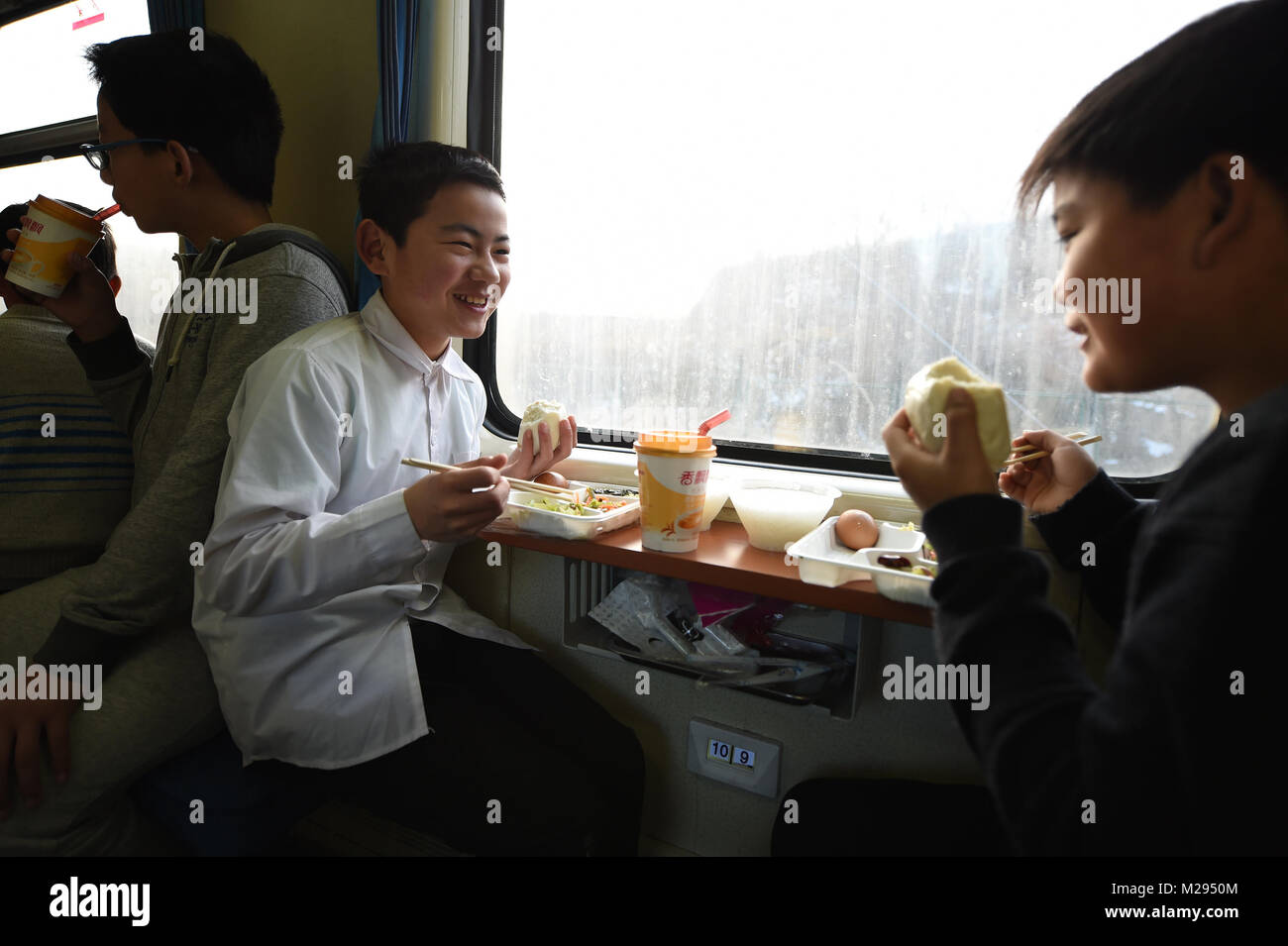 (180206) -- LONGXI, 6 febbraio 2018 (Xinhua) -- Sun Jianjun ha la colazione sul treno K419, Febbraio 2, 2018. Festival di primavera, o il nuovo anno lunare cinese, cade il 16 febbraio di quest'anno. Centinaia di milioni di cinesi ritorneranno alle loro città di appartenenza per riunioni di famiglia. 14-anno-vecchio Jianjun Sun e i suoi 15 compagni di scuola sono tra questi viaggiatori desiderosi torna alla home. Il 1 febbraio il primo giorno del 2018 Festival di Primavera di viaggio rush, hanno intensificato su un treno in Nantong dell oriente cinese della provincia di Jiangsu su un viaggio a casa che è più di duemila chilometri di distanza. Lungo la 36 Ore di percorso, hanno dovuto prendere un h Foto Stock