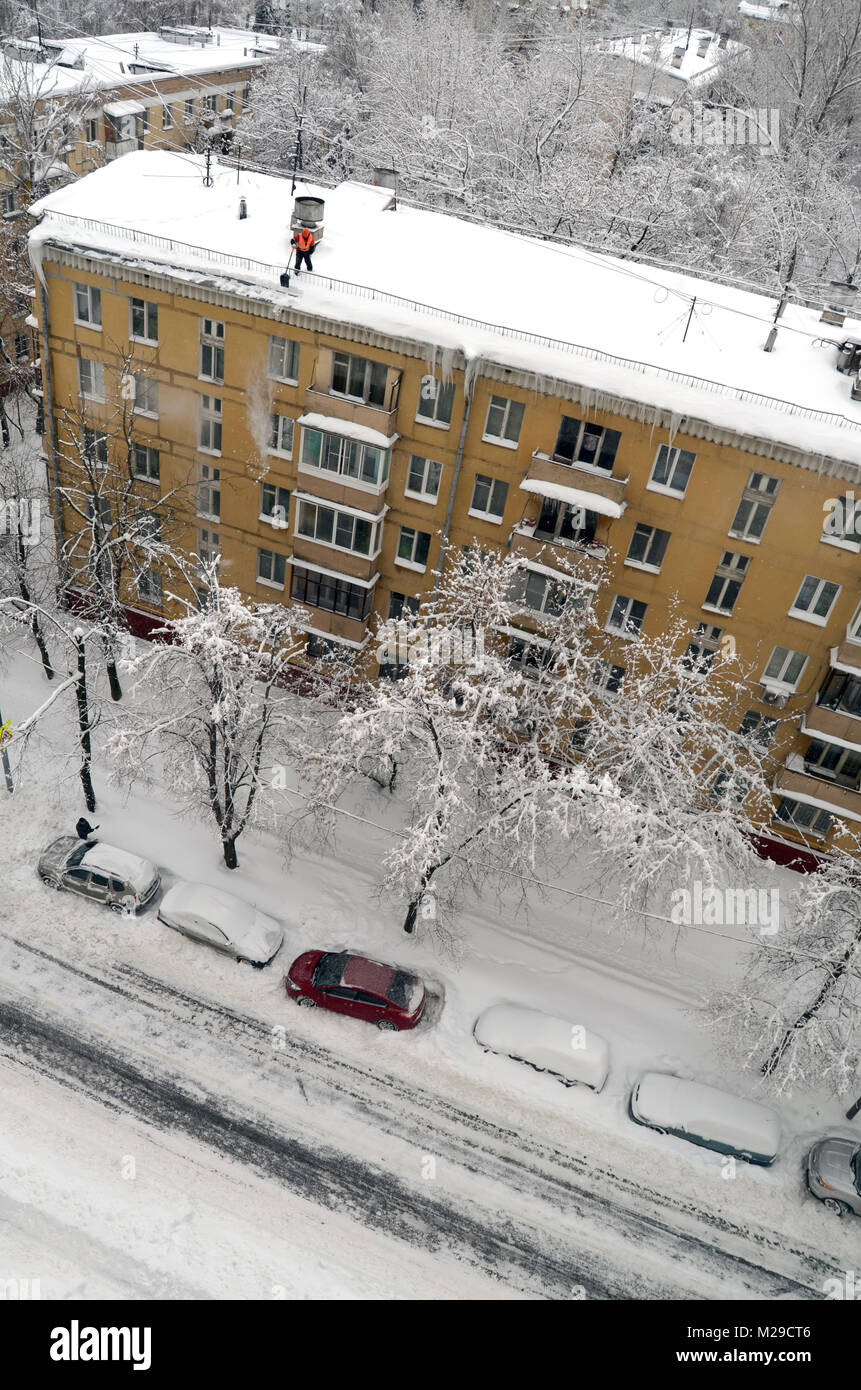 Bidello pulisce la neve dal tetto dopo la nevicata in Mosca Russia Foto Stock