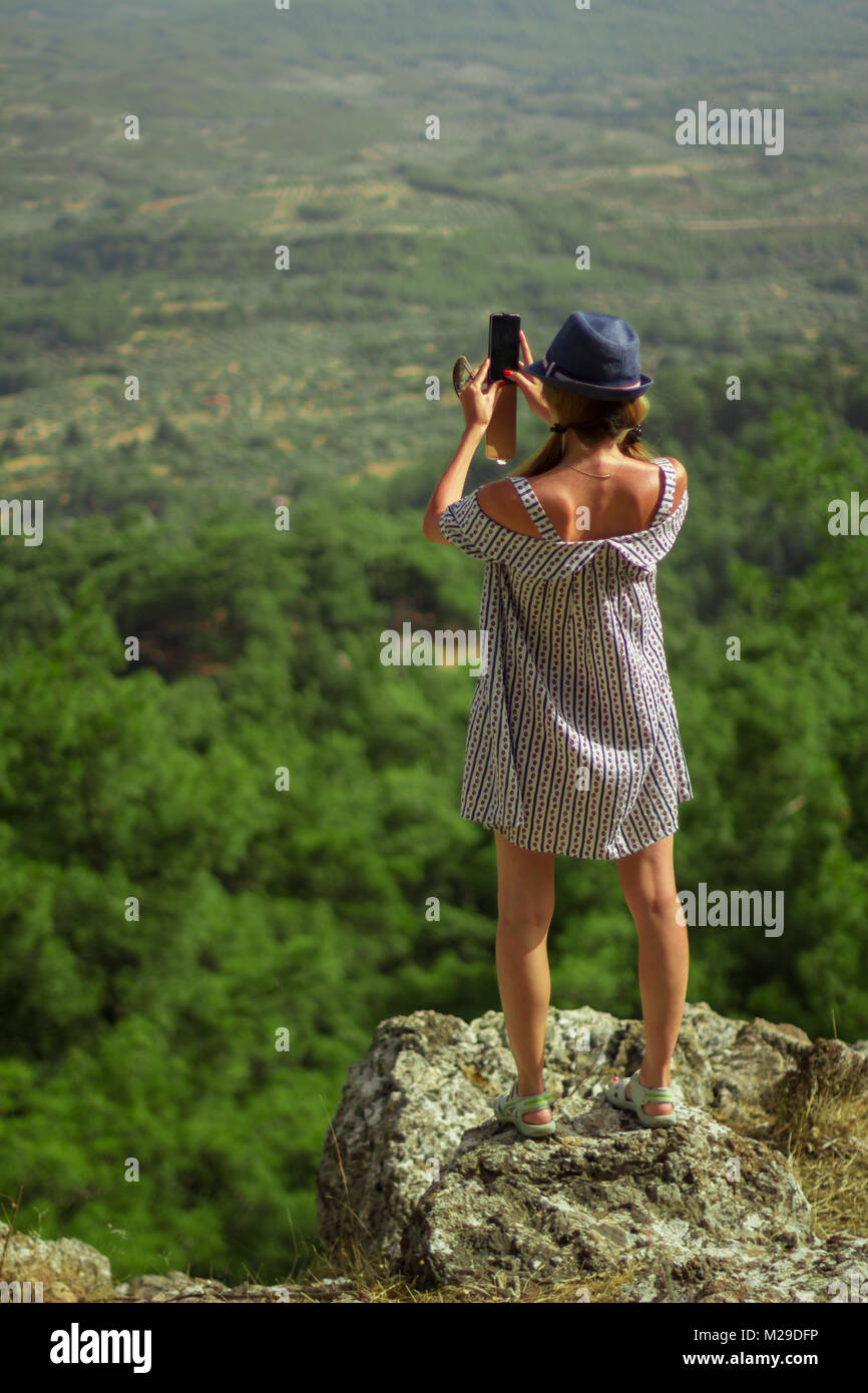 La donna caucasica in un abito di fotografare le montagne Foto Stock